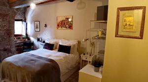 a bedroom with a bed with white sheets and a mirror at Casa el Envero in Saro