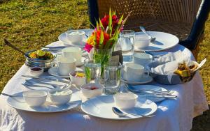 a table with plates and cups and flowers on it at GREEN VALLEY SARISKA in Tehla