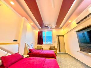 a room with two beds and a flat screen tv at Rivana Retreat in Dehradun