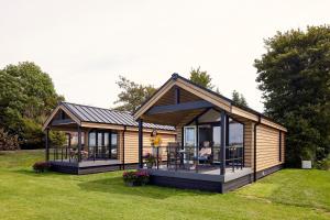 a small cabin with a deck in the grass at Tussen de Diepen in Blokzijl