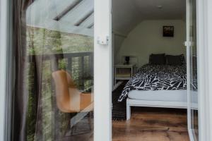 a bedroom with a black and white bed and a chair at Sturzul Negru in Păiuş