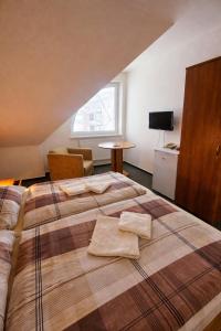 a bedroom with a large bed with two towels on it at REVIS Tachov in Tachov