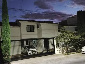 a white house with a car behind a fence at Casa al norte in Aguascalientes