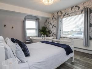 a bedroom with a bed and a window and a tub at The Wren in Colwyn Bay