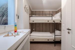 a bunk bed room with two bunk beds and a bathroom at Küstennest in Wenningstedt