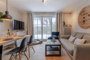 a living room with a couch and a table at Küstennest in Wenningstedt