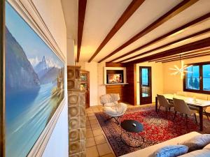 a living room with a large painting on the wall at Chalet Apartment Faulensee in Faulensee