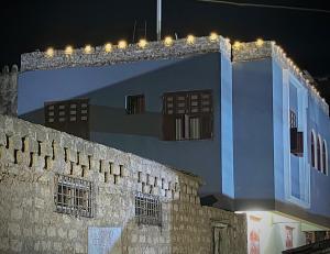 a building with lights on top of it at night at Mkunazini House in Lamu