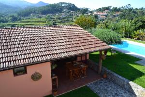 a small house with a table and a swimming pool at Casa de Fujacos in Valença