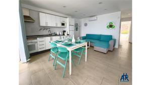 a kitchen and living room with a table and a blue couch at Arthouse Sea View - Acquamarina e Zaffiro in Puerto del Carmen