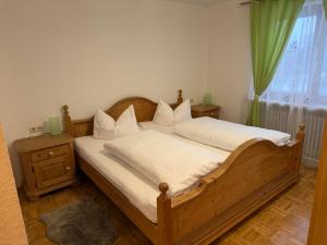 a bedroom with a wooden bed and a green curtain at Alpenblick am Kienberg in Pfronten