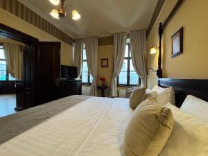 a large white bed in a bedroom with windows at Hotel Iosefin Residence in Timişoara +41 photos