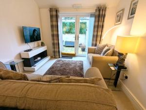 a living room with a couch and a tv at 2 Bedroom Unique Converted Constabulary in Nantwich