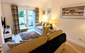 a living room with a couch and a chair at 2 Bedroom Unique Converted Constabulary in Nantwich