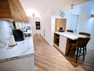 a kitchen with a counter and a kitchen island in a room at 2 Bedroom Unique Converted Constabulary in Nantwich