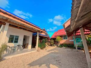 a group of houses with tables and chairs in the courtyard at Yada homestay in Ban Bu Lu