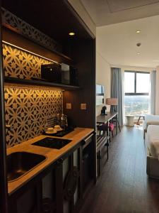 a kitchen with a sink and a room with a bed at Apec Mandala Sea View Bathtub by MLT in Mui Ne