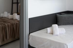 a bedroom with a bed with two towels on it at Delfini Girni Apartments in Paralia Katerinis
