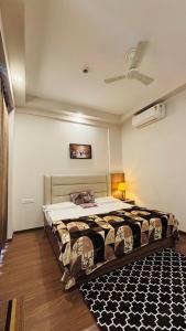 a bedroom with a bed and a ceiling fan at Skybloom stays in Greater Noida