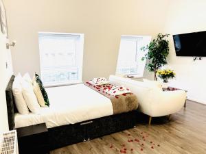 a bedroom with a white bed and a chair at Fox House, Studio Apartments in Plymouth