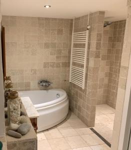 a bathroom with a white tub and a shower at Luxury guesthouse - Eik bij de dijk in Aalst