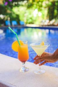 two cocktails sitting on a table next to a pool at Villa Bojana in Budva