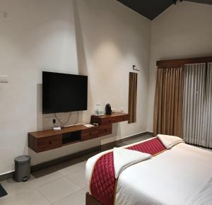 a bedroom with a bed and a flat screen tv at Pulicat Lake View Resort APTDC in Tada