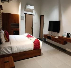 a bedroom with a bed and a flat screen tv at Pulicat Lake View Resort APTDC in Tada +14 photos