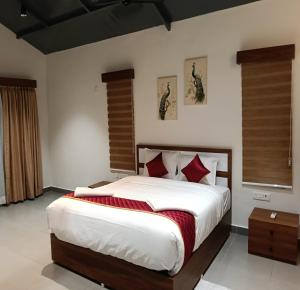a bedroom with a large bed with red pillows at Pulicat Lake View Resort APTDC in Tada