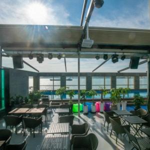 a patio with tables and chairs on a building at Hotel Wolmido in Incheon