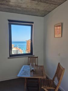 a table and a chair in a room with a window at 123 Muda Life in Sesimbra