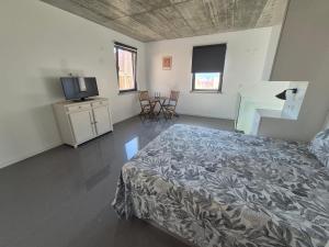 a bedroom with a bed and a flat screen tv at 123 Muda Life in Sesimbra