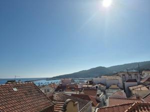 a view of a city with buildings and the ocean at 123 Muda Life in Sesimbra