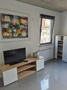 a living room with a flat screen tv on a cabinet at 123 Muda Life in Sesimbra