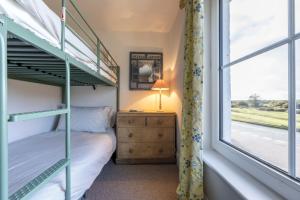 a bedroom with a bunk bed and a window at Hatchet Pond Cottage in Beaulieu