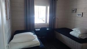 a small room with two beds and a window at Villa Naava in Lukkarinsaari