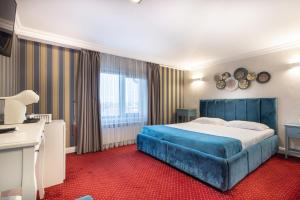 a hotel room with a large bed and a desk at Hotel City Break in Galaţi +78 photos