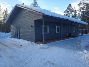 a cabin in the snow with snow on the roof at Villa Naava in Lukkarinsaari +5 photos