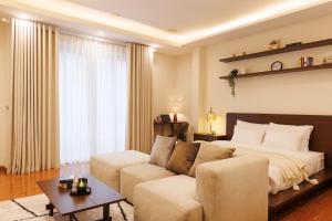 a living room with a bed and a couch at Beloved Summer House in Hanoi