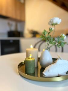 a plate with two candles and a vase with flowers at Entre Mer et Dunes de Pin in Neufchâtel-Hardelot