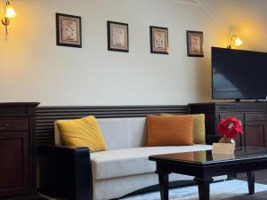 a living room with a couch and a flat screen tv at Hotel Iosefin Residence in Timişoara
