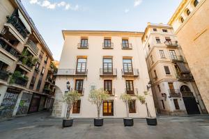 a large building with two trees in front of it at Hotel San Lorenzo Boutique Catedral in Valencia
