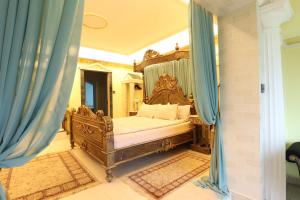 a bedroom with a canopy bed with blue curtains at Ferndale Luxury Boutique Bed & Breakfast in Keel