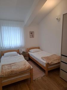 a bedroom with two beds and a window at Terrace Apartmani in Široki Brijeg