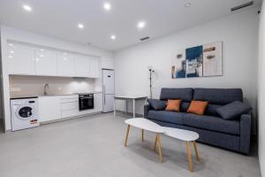 a living room with a couch and a table and a kitchen at Iberflat Apartamentos Alfabega in Paterna