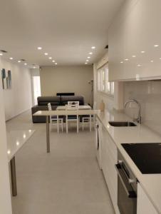 a kitchen and living room with a table and a couch at Iberflat Apartamentos Alfabega in Paterna