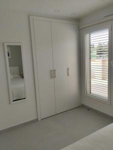 a white room with white cabinets and a window at Iberflat Apartamentos Alfabega in Paterna +9 photos