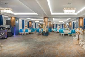 a banquet hall with blue tables and chairs at Hotel City Break in Galaţi
