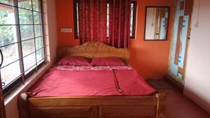 a bed in a room with orange walls and windows at Danny's Homestay Coorg in Madikeri