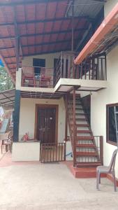 a house with a staircase and a chair in front of it at Danny's Homestay Coorg in Madikeri